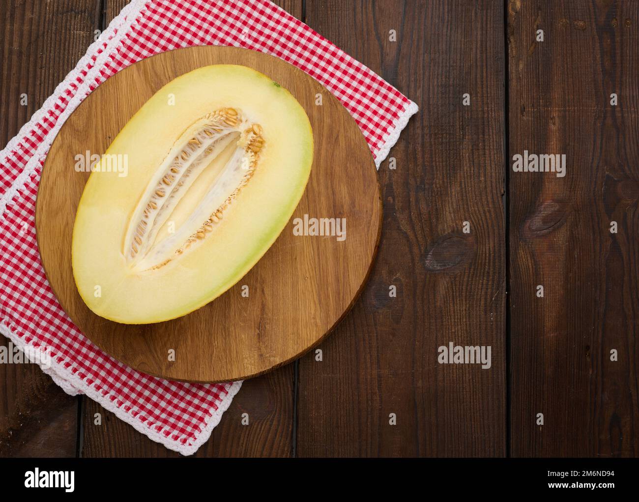 Metà melone maturo su tavole rotonde di legno, vista dall'alto Foto Stock