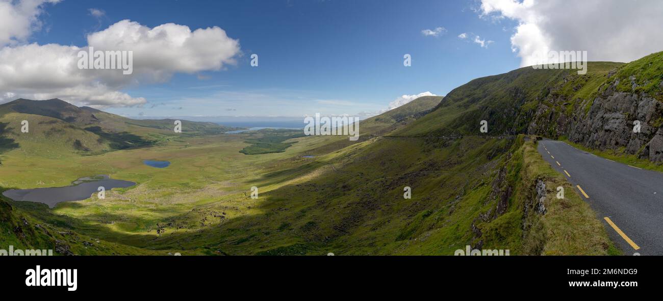 Panorama con la ripida e tortuosa strada di montagna che conduce alla cima del Passo di Connor sulla penisola di Dingle nella contea Foto Stock