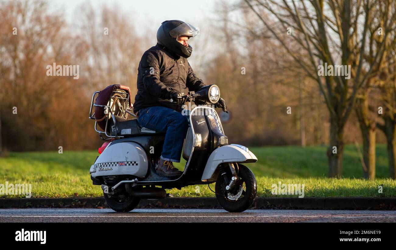 Uomo in moto Vespa Foto Stock