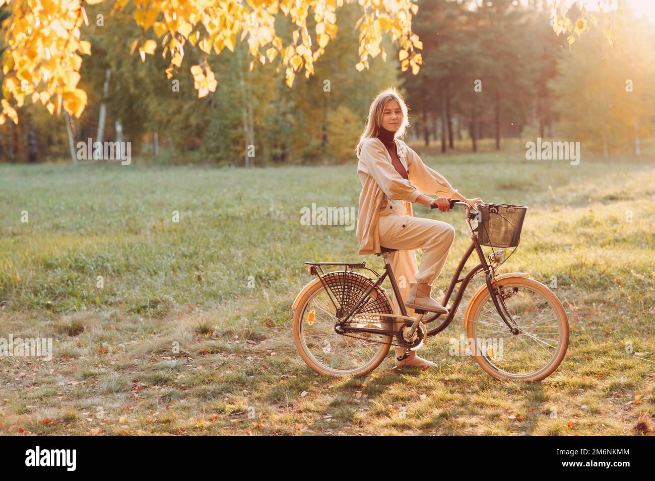Felice giovane donna attiva in bicicletta nel parco autunnale Foto Stock