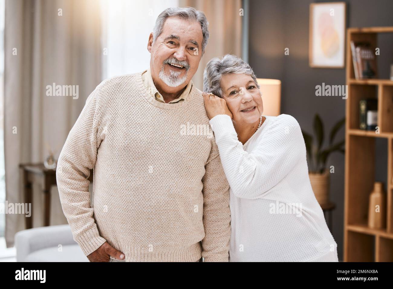 Amore, ritratto o vecchia coppia abbracciare in casa soggiorno godendo di qualità tempo di legame in felice impegno di matrimonio. Fiducia, sostegno o donna anziana in Foto Stock