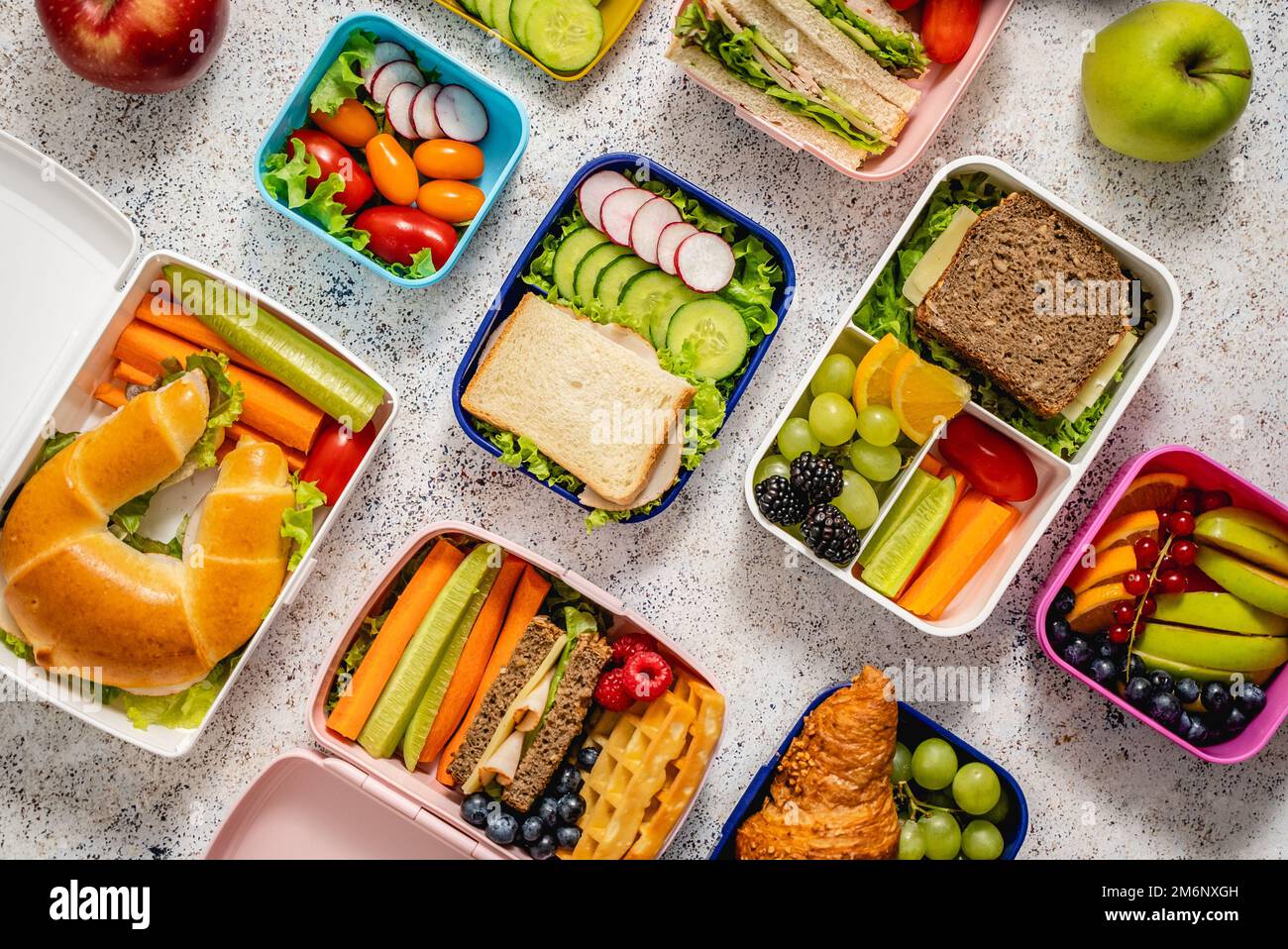 Shot di lunchboxes scuola con vari pasti nutrienti sani su sfondo di pietra Foto Stock