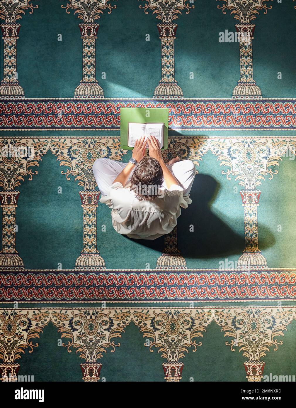 Religione, corano e uomo musulmano che leggono per l'educazione spirituale, imparando il culto e la fede durante il ramadan. Islam, santo e sopra di una persona islamica Foto Stock