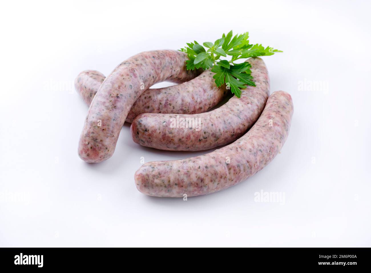 Crudo AllgÃ¤u bratwurst guarnito con prezzemolo e offerto come primo piano su sfondo bianco con spazio di testo Foto Stock