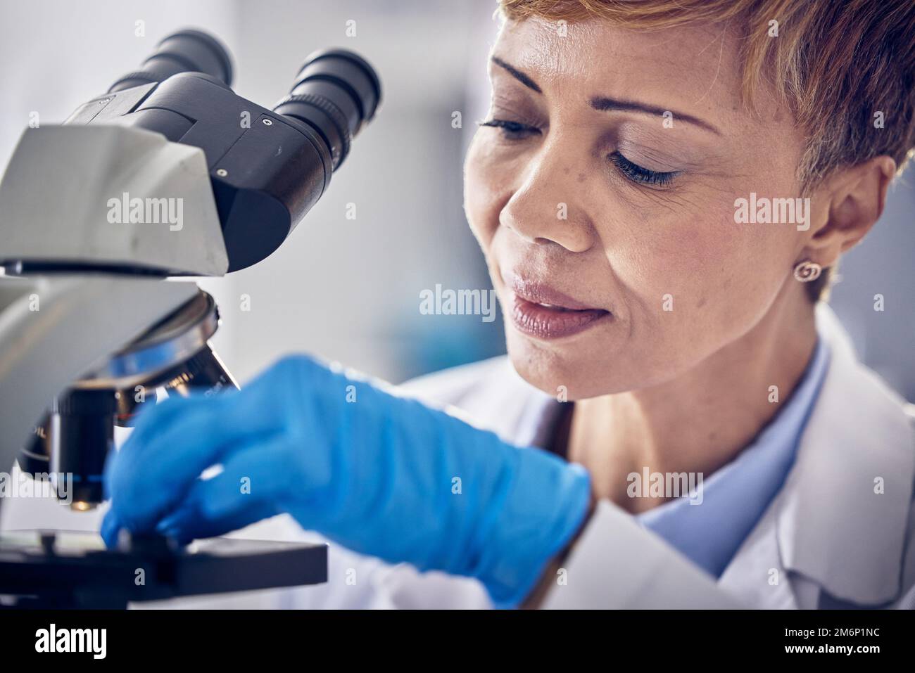 Scienza, laboratorio e donna nera al microscopio, ricerca per lo sviluppo di vaccini. Assistenza sanitaria, innovazione medica e donna scienziata senior in Foto Stock
