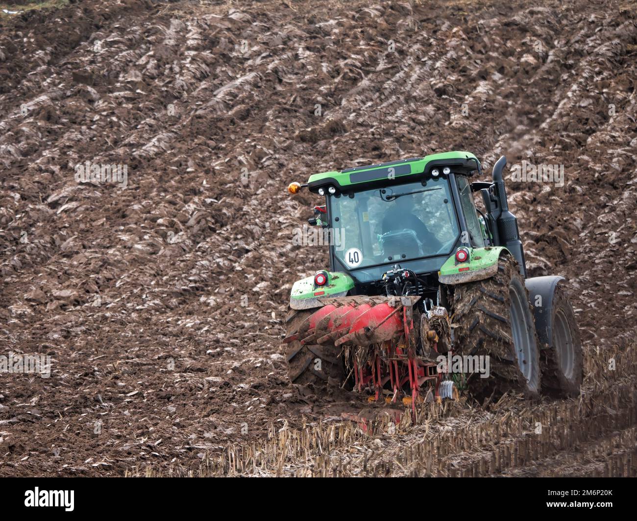 Trattore agricolo che solfora il campo di mais a fine autunno Foto Stock