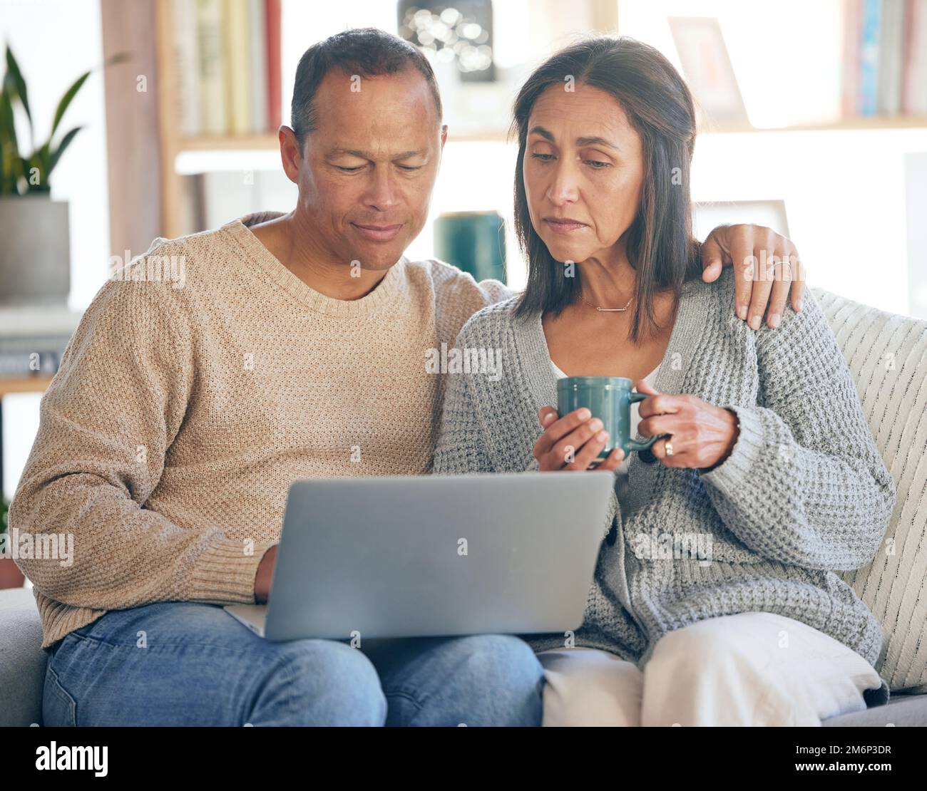 Film, social media e coppia senior con computer portatile per il sito Web, film e relax sul divano del soggiorno con caffè. Internet, e-mail e anziani e. Foto Stock