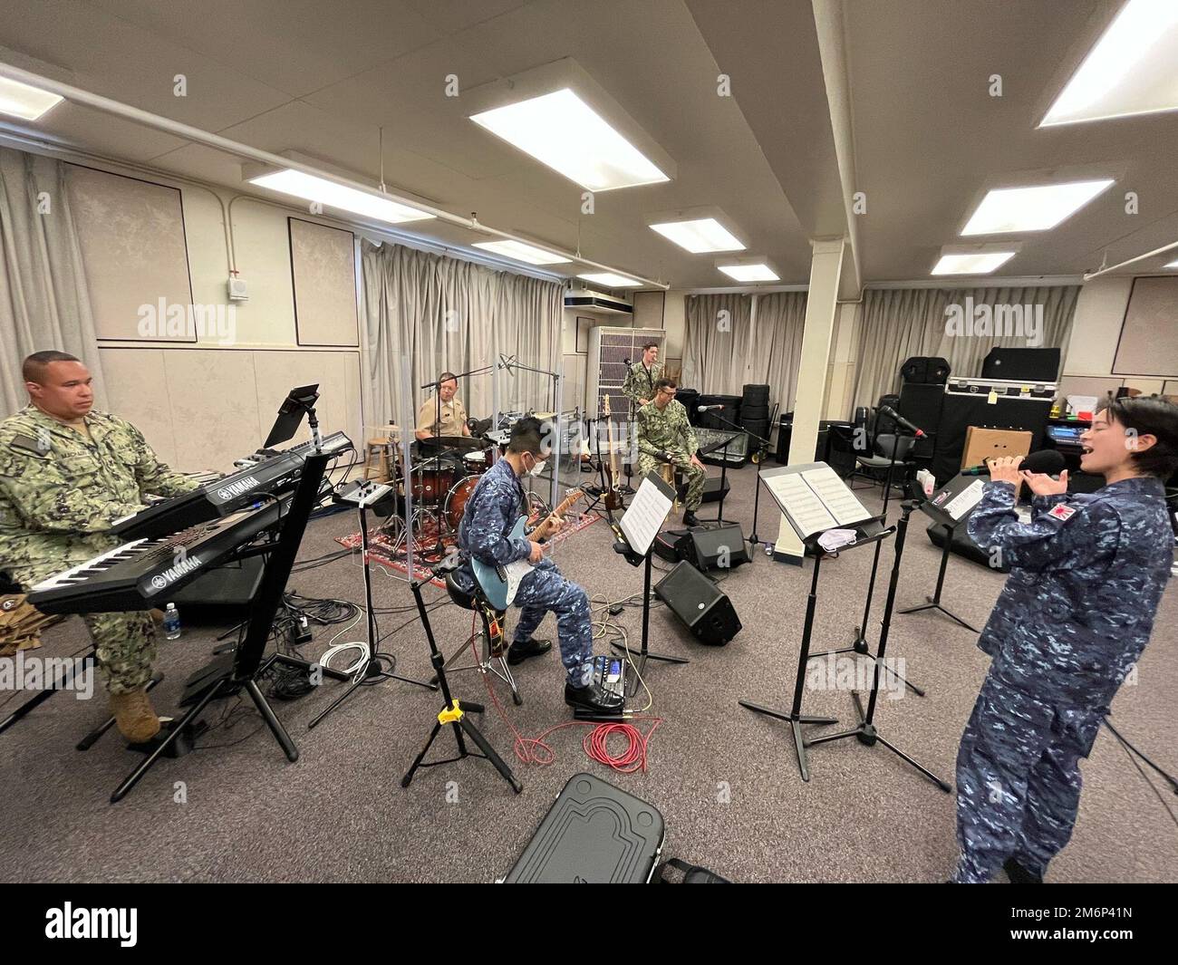 BASE COMUNE PEARL HARBOR-HICKAM, Hawaii (3 maggio 2022) musicisti assegnati a Commander, Stati Uniti L'ensemble rock della Pacific Fleet Band, "Pipeline", e i musicisti della Japan Maritime Self-Defense Force (JMSDF) della classe 2nd Yukari Miyake e Yushi Wakai, entrambi assegnati alla JMSDF Band di Tokyo, si esibiscono in preparazione alle esibizioni del Pacific Partnership 2022. La missione del Pacific Partnership è quella di lavorare insieme con le nazioni ospitanti e partner per migliorare l’interoperabilità regionale e le capacità di risposta alle catastrofi, aumentare la stabilità e la sicurezza nella regione e promuovere amicizie nuove e durature in tutta la regione Foto Stock