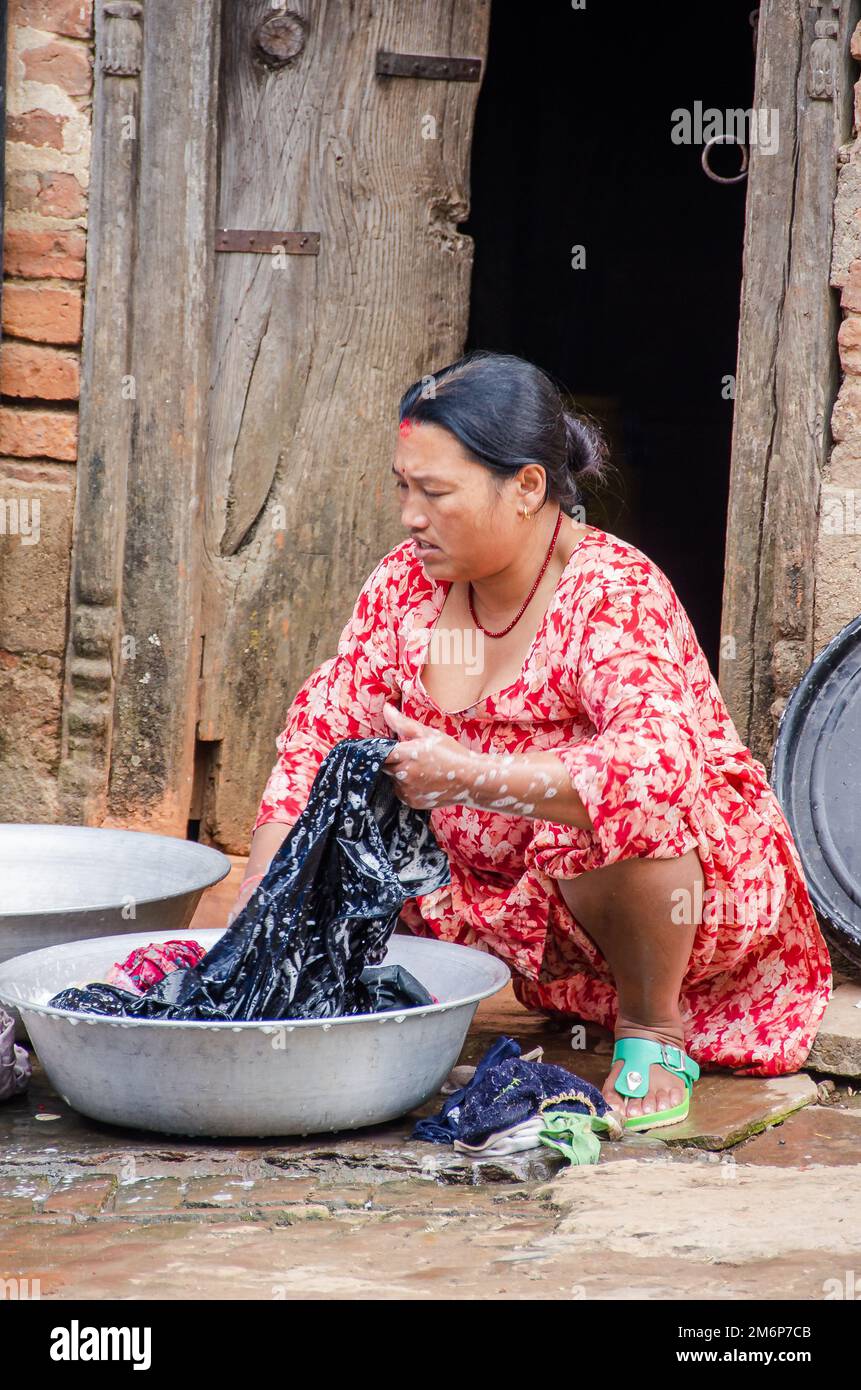 Facce del Nepal: Donna che lavano vestiti Foto Stock
