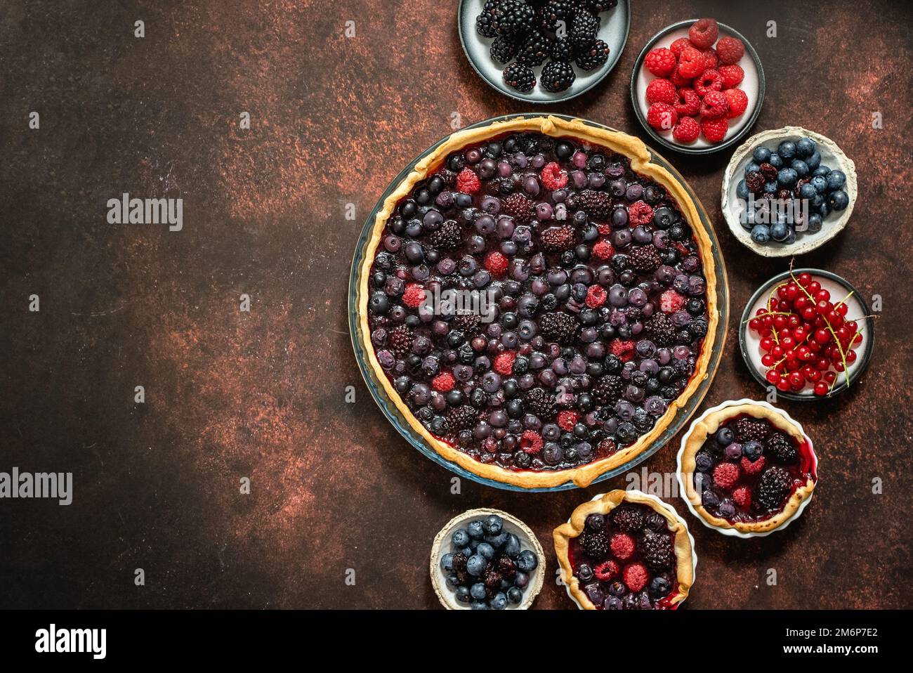 Torta di frutti di bosco dolci autunnali fatta in casa su sfondo rustico scuro Foto Stock
