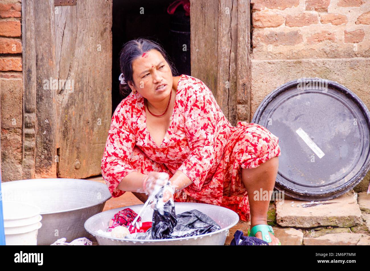 Facce del Nepal: Donna che lavano vestiti Foto Stock
