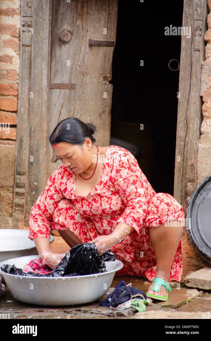 Facce del Nepal: Donna che lavano vestiti Foto Stock