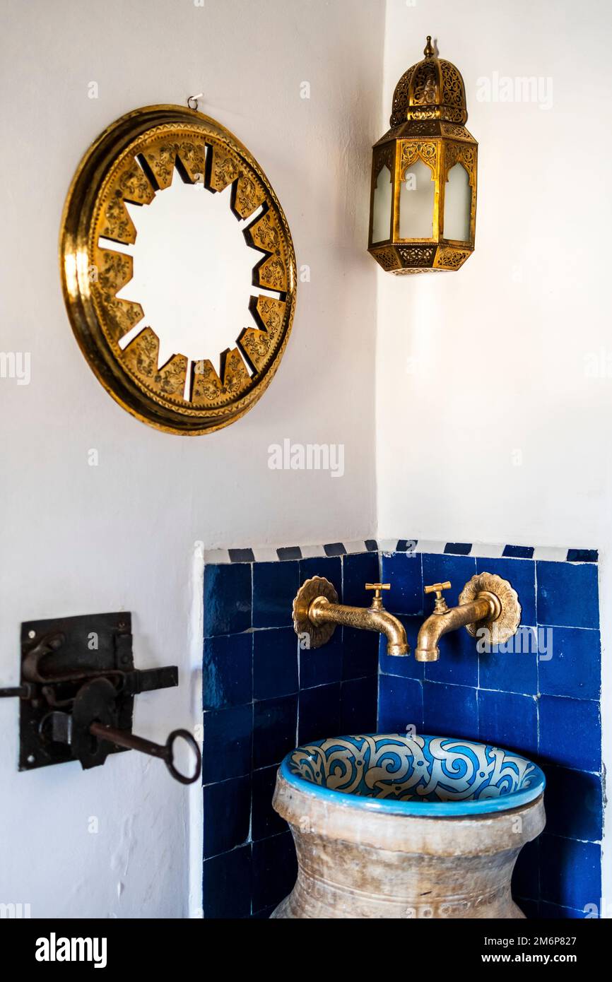 Lavabo tradizionale e specchio dorato e lampada nell'angolo della camera da letto del riad, Medina di Fez, Marocco, Nord Africa Foto Stock