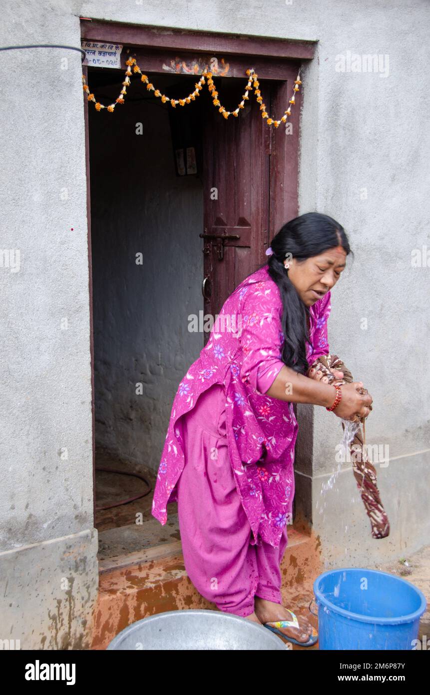 Facce del Nepal: Donna che lavano vestiti Foto Stock