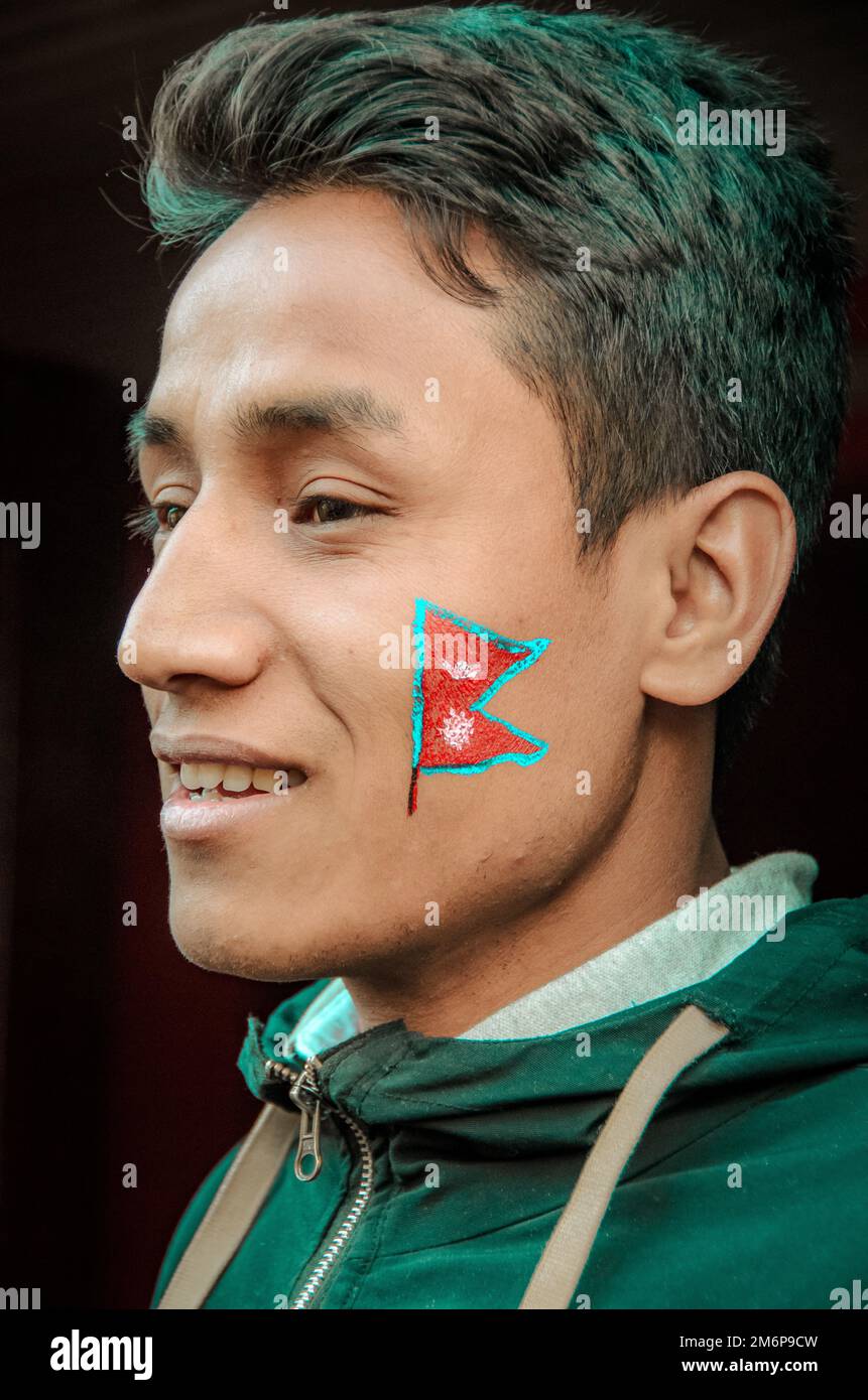 Facce del Nepal: Giovane uomo adulto con vernice facciale Foto Stock