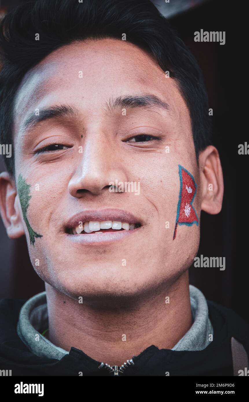 Facce del Nepal: Giovane uomo adulto con vernice facciale Foto Stock
