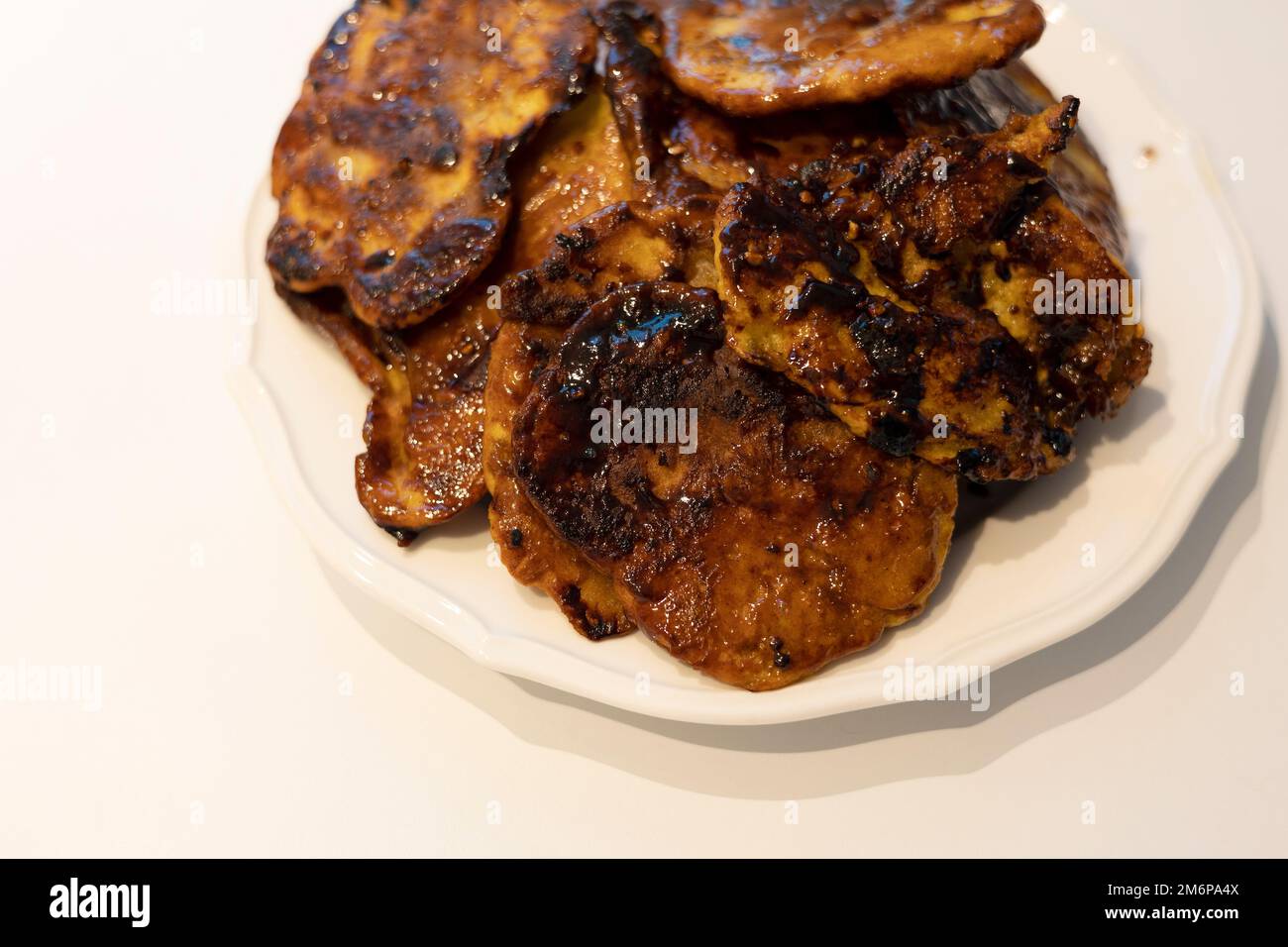 Un mucchio di frittelle calde coreane che un po' bruciavano sul piatto bianco Foto Stock