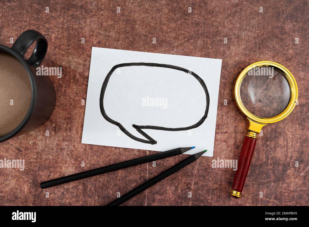 Disegno di bolla di pensiero su carta con tazza da caffè, matite colorate e lente d'ingrandimento posizionate su legno. Rappresenta la ricerca Foto Stock