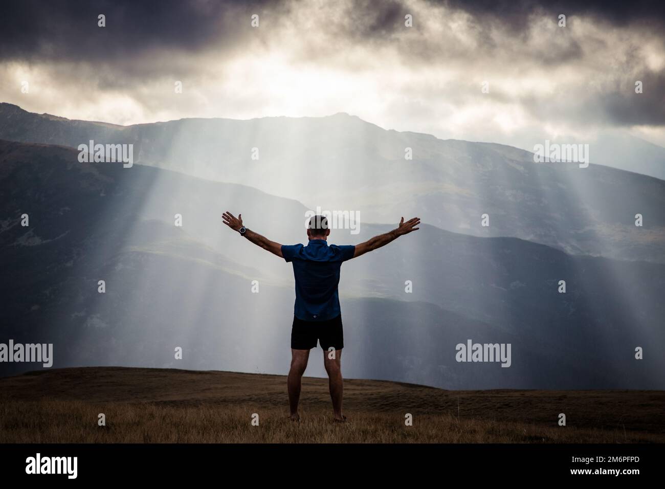 Uomo silhouette contro le luci celesti in montagna concetto di libertà Foto Stock