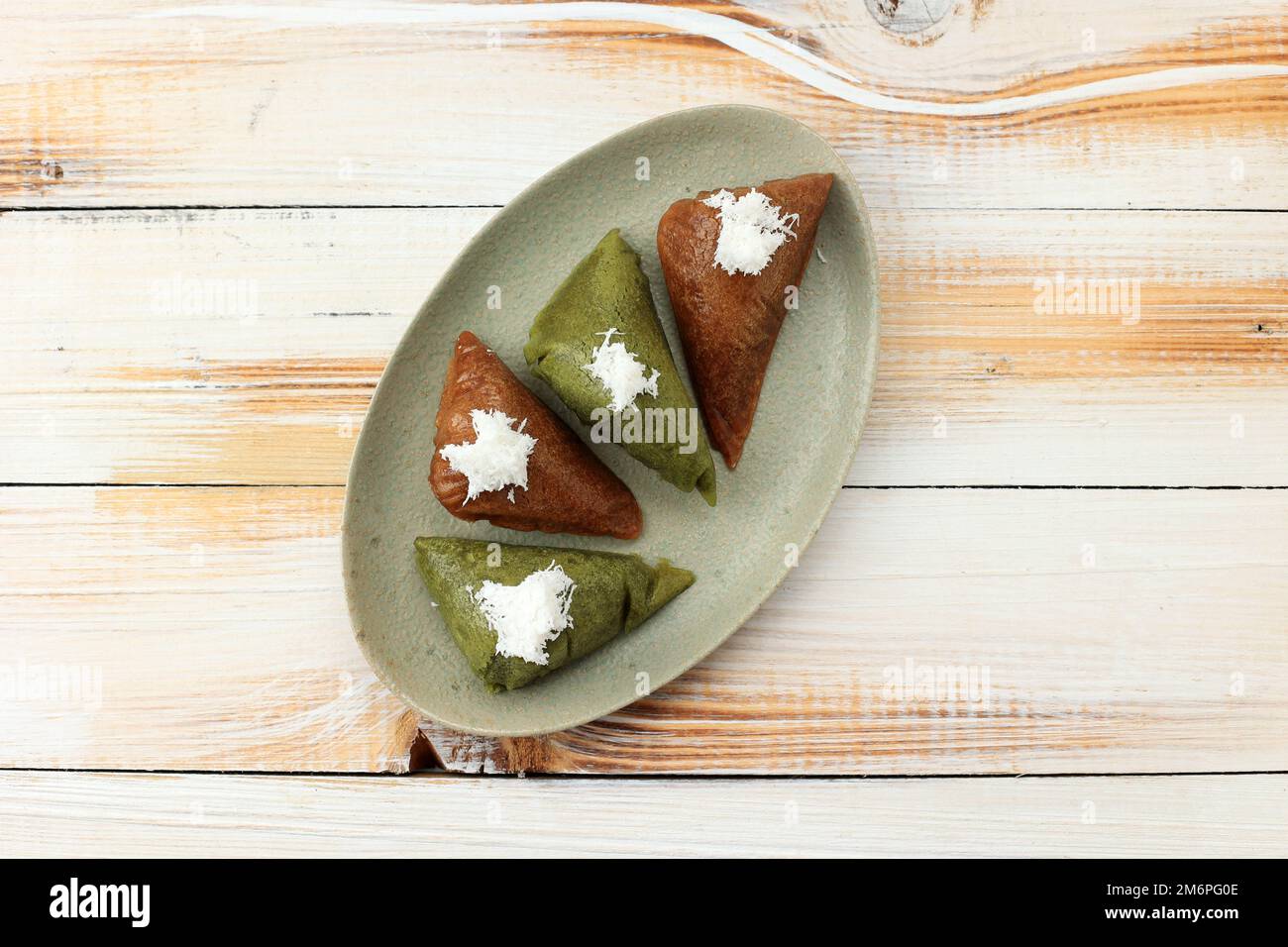 Apang Panas Bugis o Apem Makassar, tradizionale spuntino al vapore a base di riso, zucchero di palma e latte di cocco. Farcitura con cocco grattugiato Foto Stock