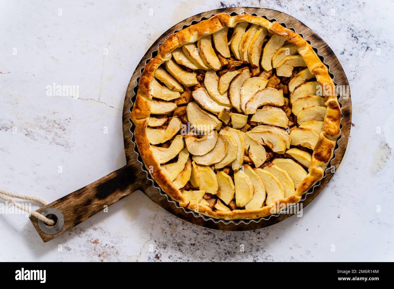 Torta di mele appena sfornata con frutta su un tavolo di pietra Foto Stock