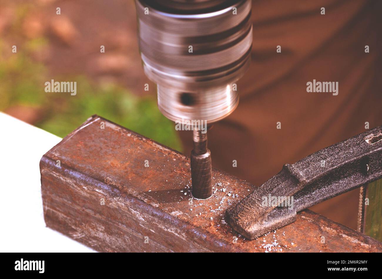 Lavorare con il metallo. Le mani degli uomini con un trapano Foto Stock