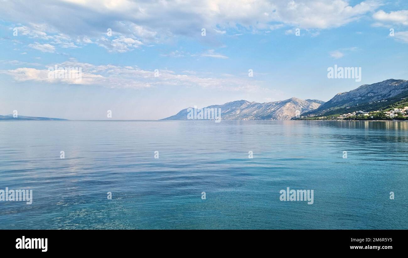 Bellissima riva del mare Adriatico. Vista sulla baia con paesaggio nuvolato. Alba Foto Stock