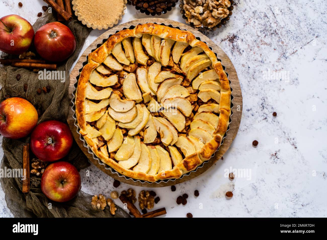 Torta di mele appena sfornata con frutta su un tavolo di pietra Foto Stock