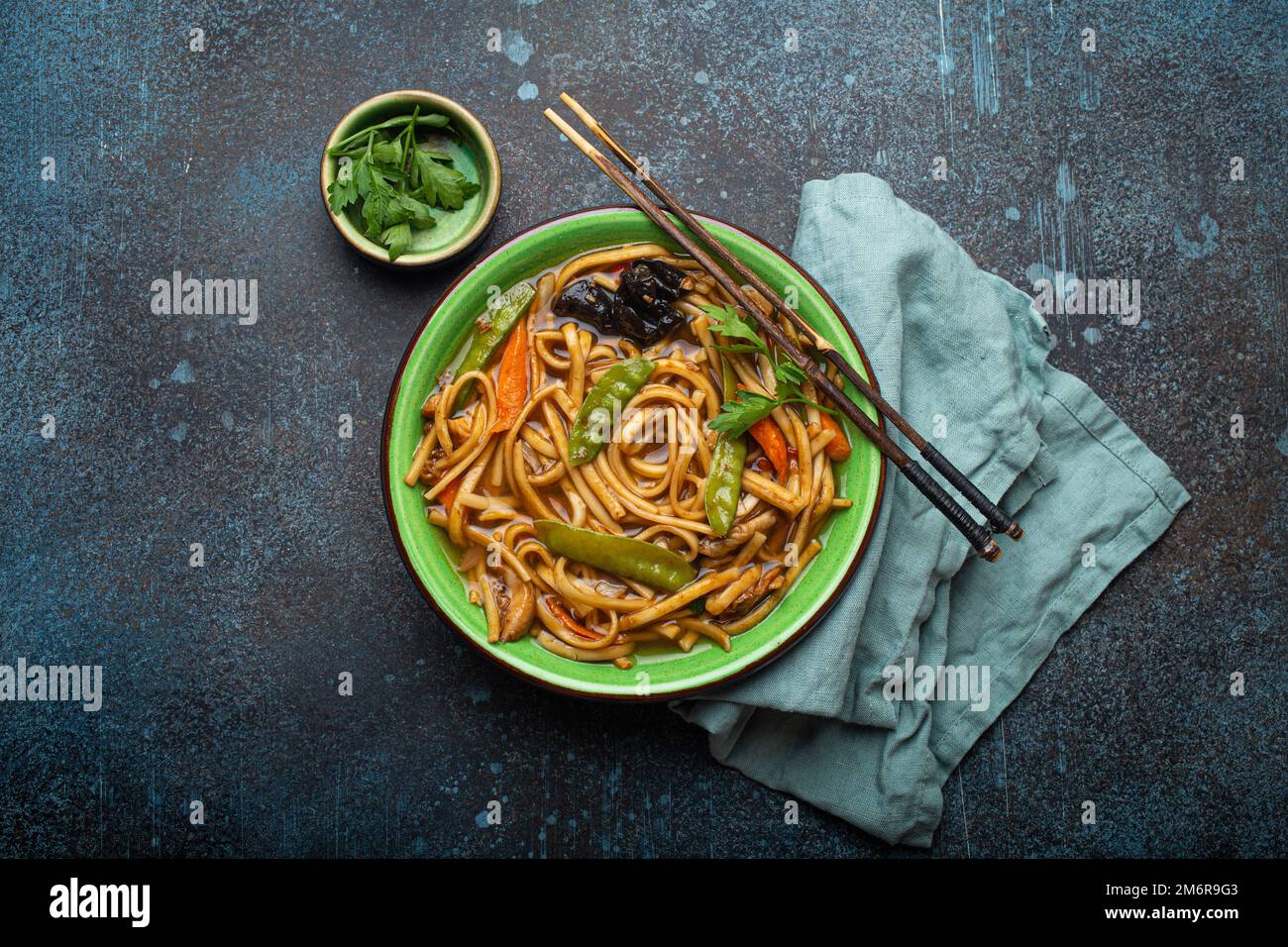 Zuppa asiatica con noodle di udon, pollo e verdure in un recipiente in ceramica verde Foto Stock