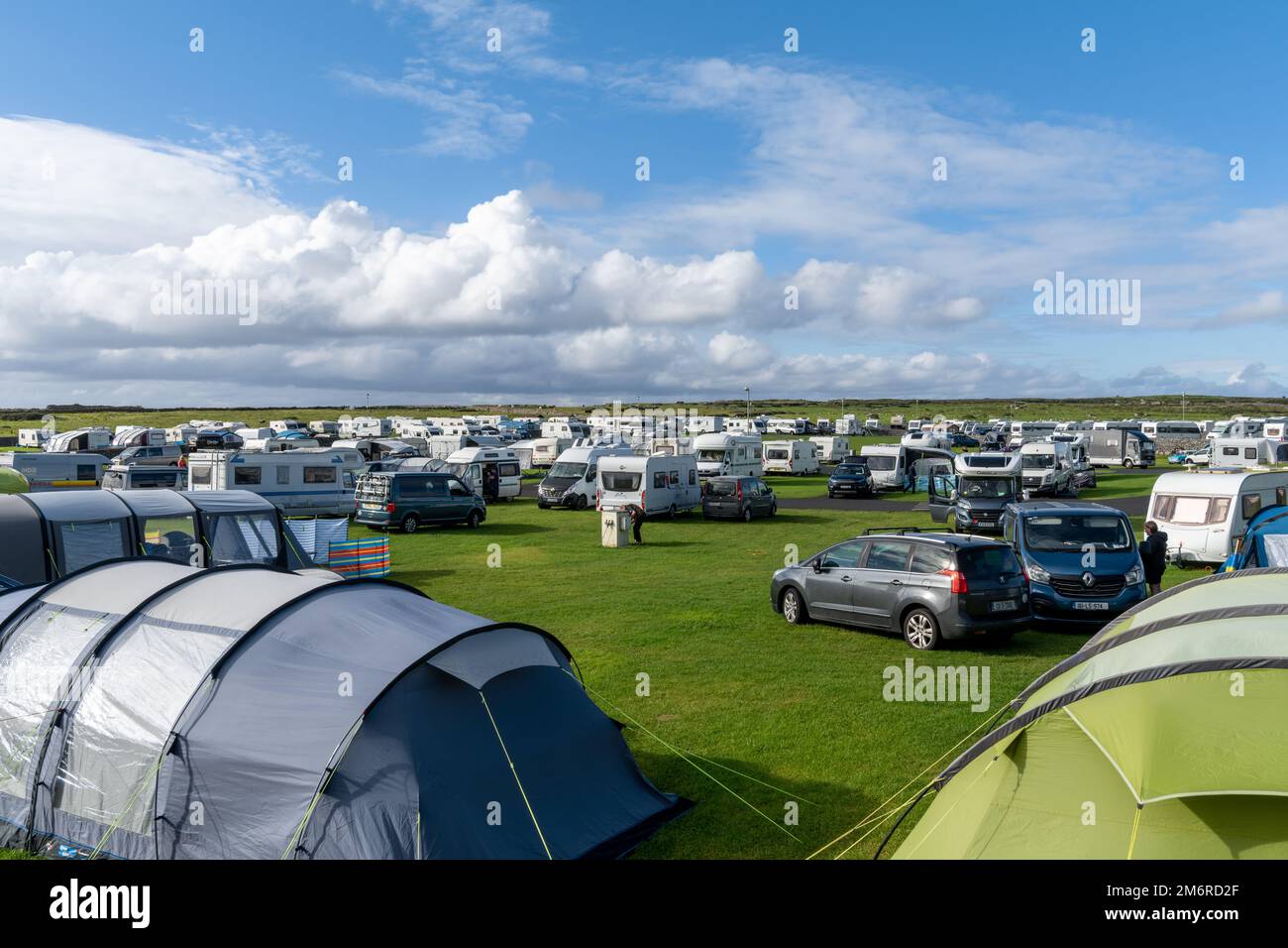 Vista di un campeggio affollato e pieno in alta estate con molte tende e roulotte Foto Stock