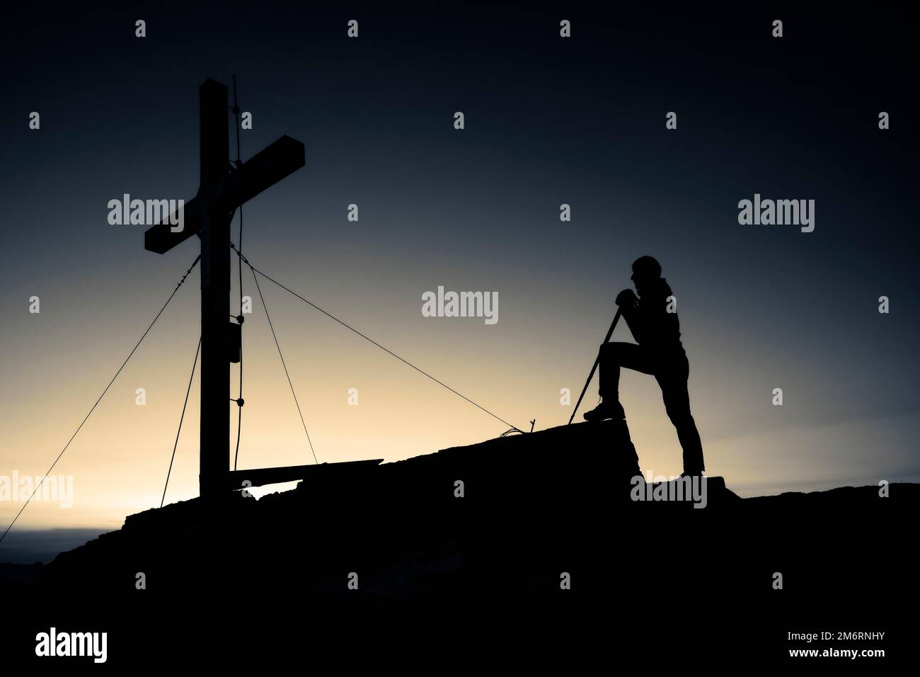 Gli alpinisti alla croce sommitale del Namloser Wetterspitze al tramonto con Lechtaler Alpen, Namlos, Reutte, Lechtal, Ausserfern, Tirolo, Austria Foto Stock