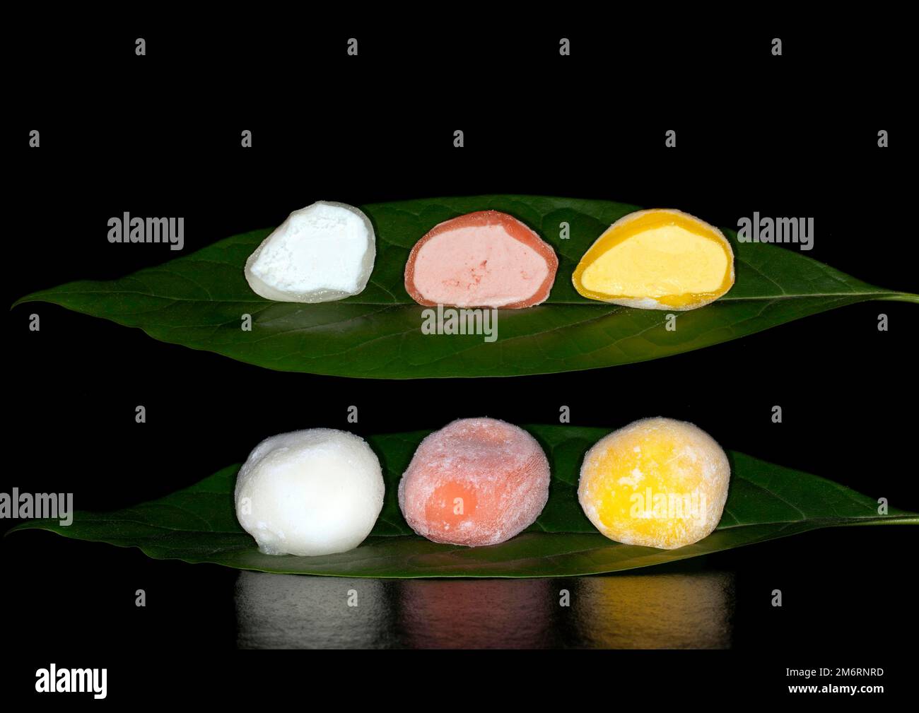 Gelato giapponese mochi ripieno di yuzu, mango e fragola, fotografia alimentare con sfondo nero Foto Stock