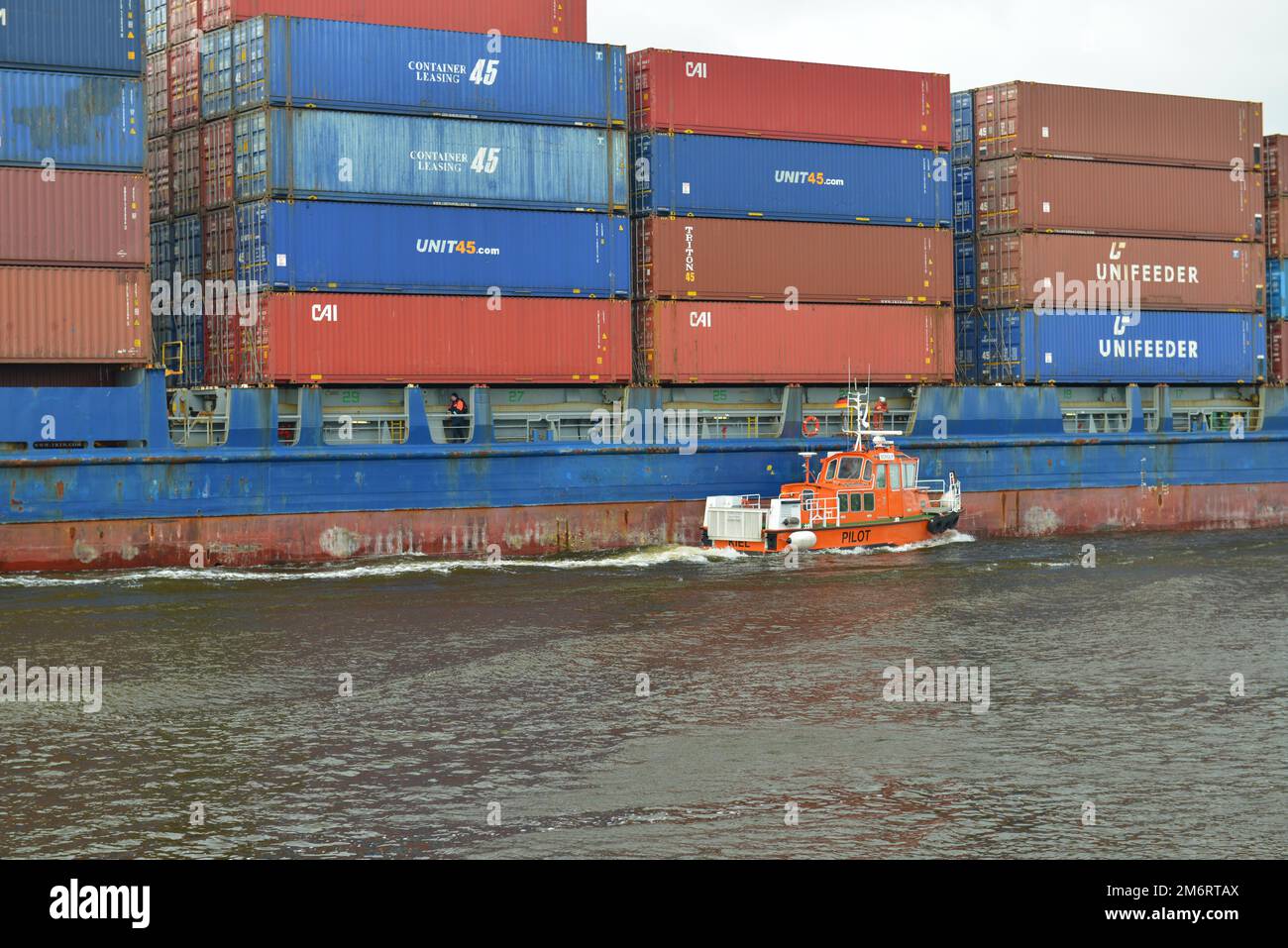 Barca pilota e nave container che navigano nel canale Kiel, Schleswig-Holstein, Germania Foto Stock