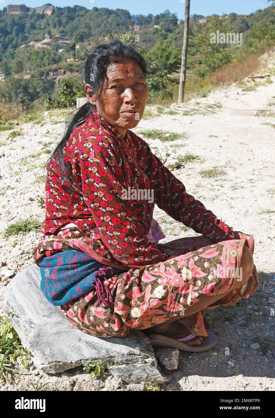 Donna nepalese con anello nasale e tika fronte seduta a terra, gruppo etnico Tamang, valle di Kafalchur, Nagarkot, provincia di Bagmati, Bhaktapur Foto Stock
