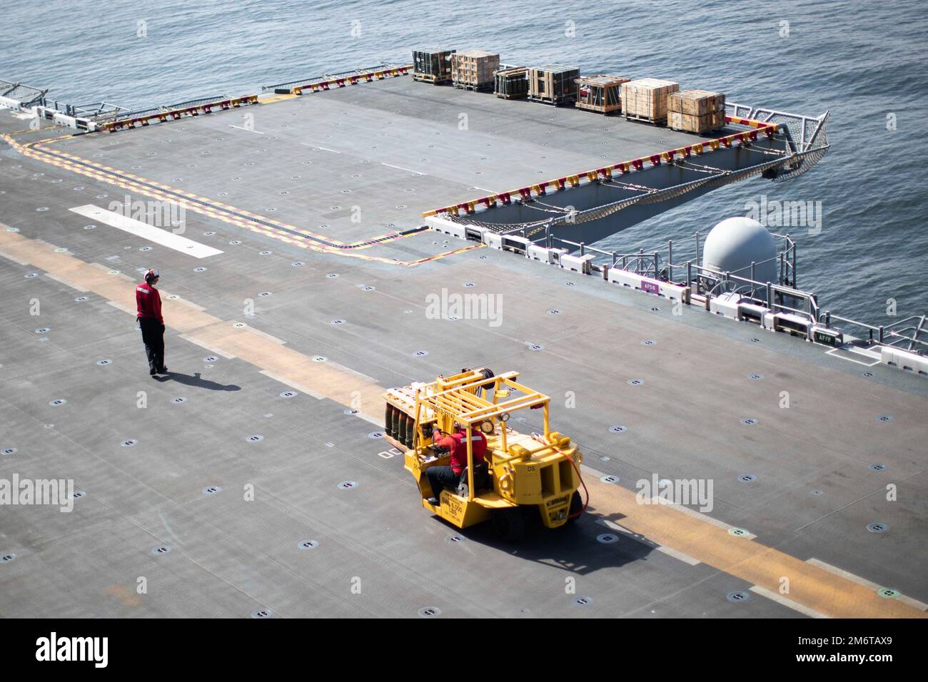 220505-N-CZ759-1086 OCEANO PACIFICO (5 maggio 2022) – i marinai trasportano pallet di munizioni sul ponte di volo a bordo del vettore d'assalto anfibio USS Tripoli (LHA 7), 5 maggio 2022. Tripoli sta conducendo operazioni di routine nella U.S. 3rd Fleet. Foto Stock