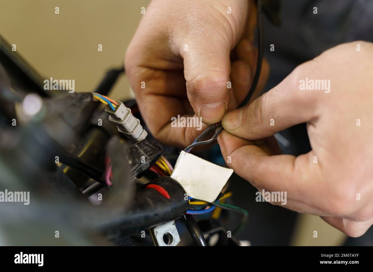 Il meccanico ordina i chip per il collegamento di apparecchiature elettriche in una motocicletta. Primo piano. Concetto di trasporto Foto Stock