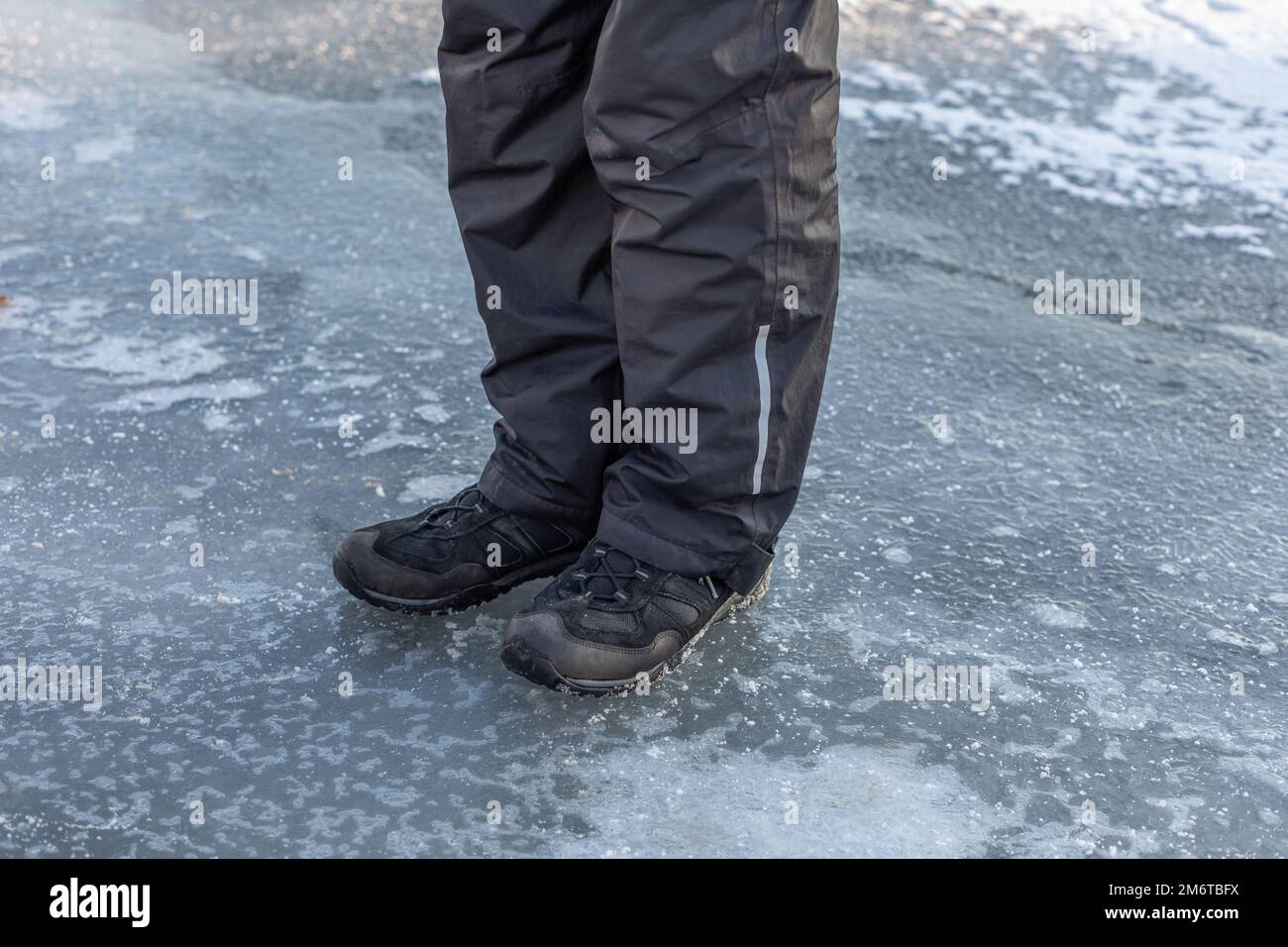 l'uomo si erge sul sottile ghiaccio di un lago ghiacciato Foto Stock