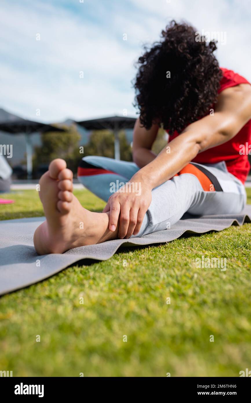 Uomo biraciale che pratica yoga e stretching in giardino Foto Stock