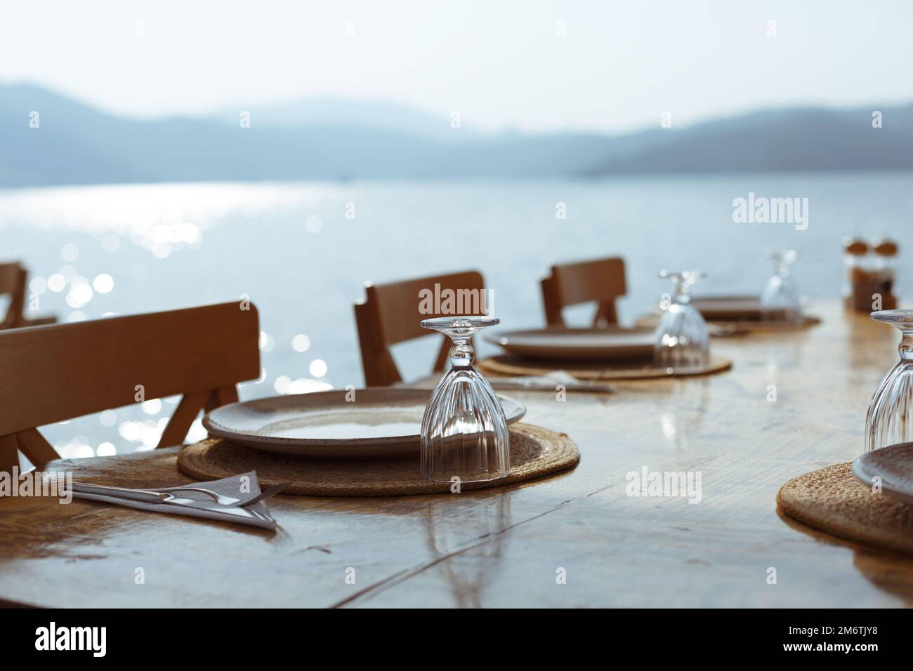 Tavolo da pranzo. Tavolo ristorante all'aperto con posate e vista mare. Ristorante all'aperto con vista sul mare. Impostazione della tabella Foto Stock