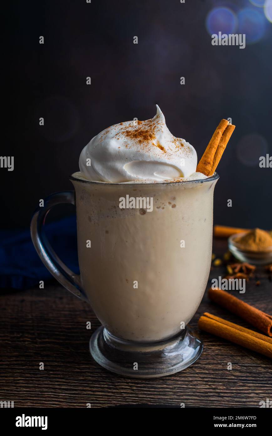 Chai Frappuccino in una tazza di vetro con panna montata: Frappuccino fatto con tè chai e gelato alla vaniglia guarnito con un bastoncino di cannella Foto Stock