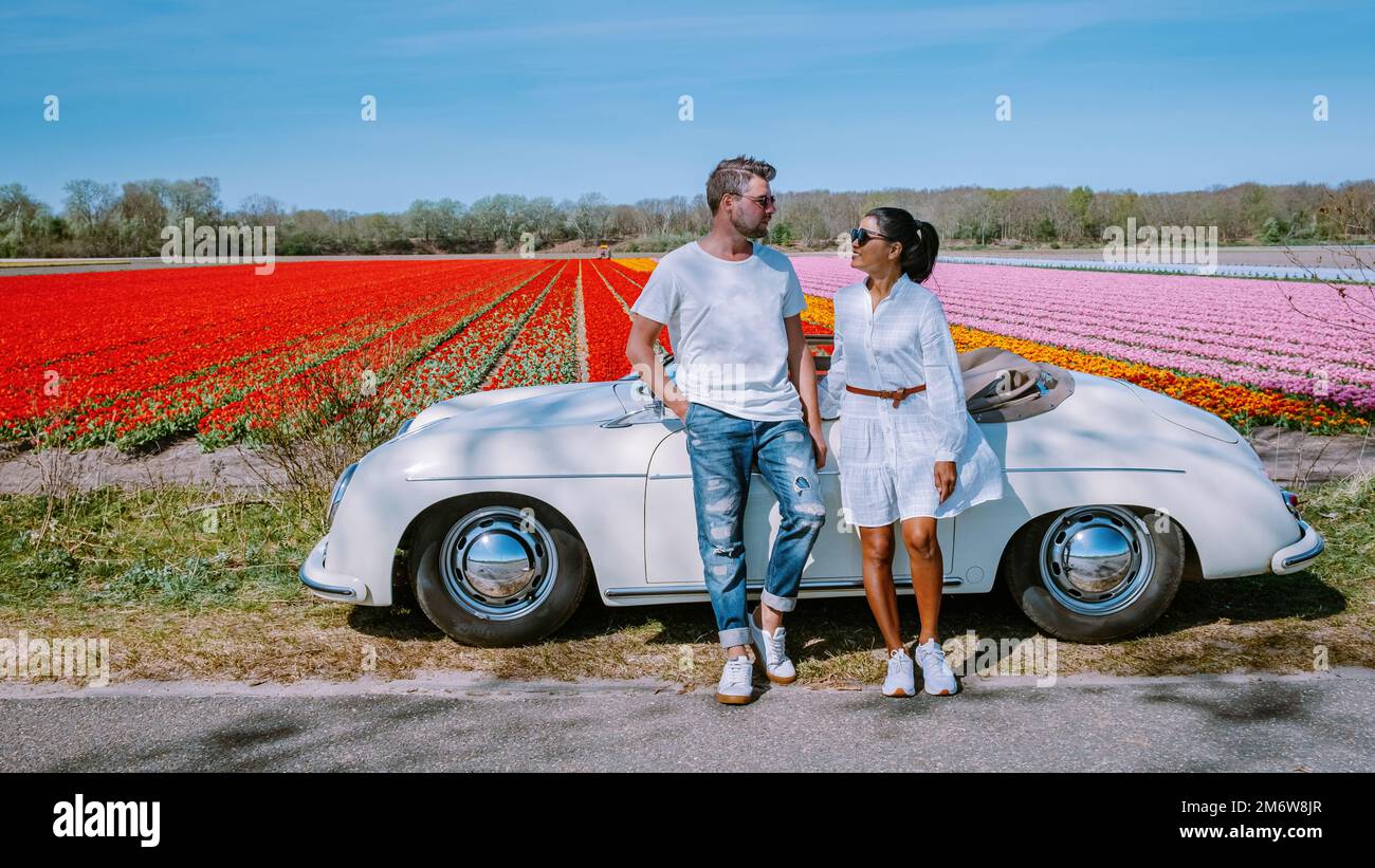 Lisse Netherlands coppia fare un viaggio su strada con una vecchia auto d'epoca nella regione olandese bulbo fiore con campi di tulipano durante la primavera Foto Stock Lisse Netherlands coppia fare un viaggio su strada con una vecchia auto d'epoca nella regione olandese bulbo fiore con campi di tulipano durante la primavera Foto Stock