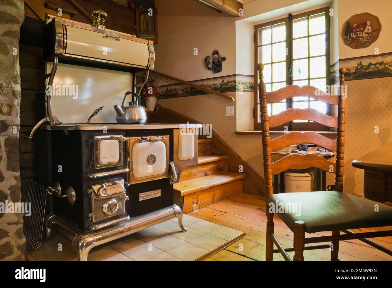 La stufa da cuoco modello retrò Sweet Heart degli anni '1850 realizzata a mano da Elmira lavora in cucina all'interno di una casa in legno ricostruita nel 1980. Foto Stock