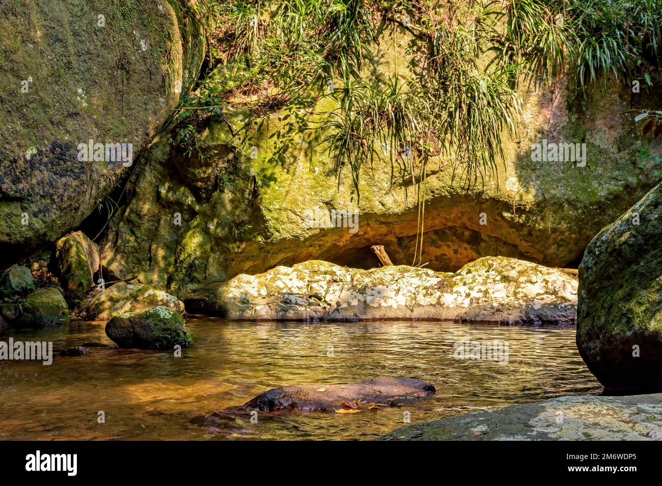Fiume che scorre attraverso le rocce e la foresta pluviale sull'isola di Ilhabela Foto Stock