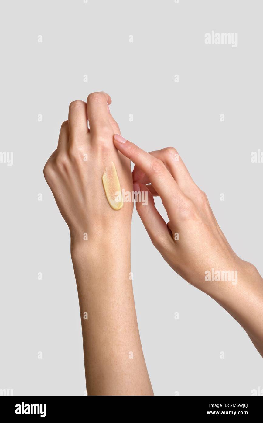 Donna che applica la lozione alla mano. Routine quotidiana di cura della pelle e del corpo. Primo piano. Foto Stock