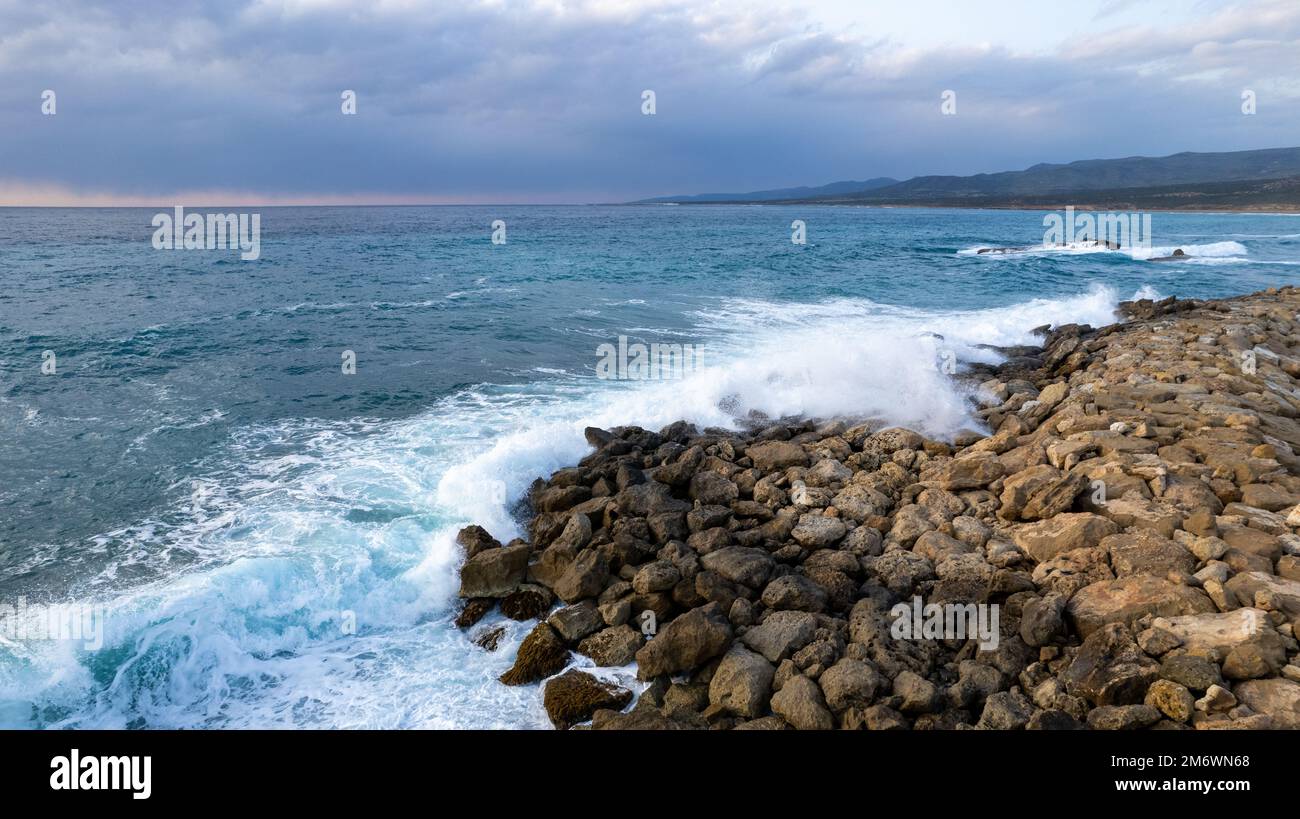 Mare paesaggio spiaggia onde ventose che colpiscono la barriera marina della spiaggia. Il drone ha girato il mare con le onde del vento. Mare tempestoso Foto Stock