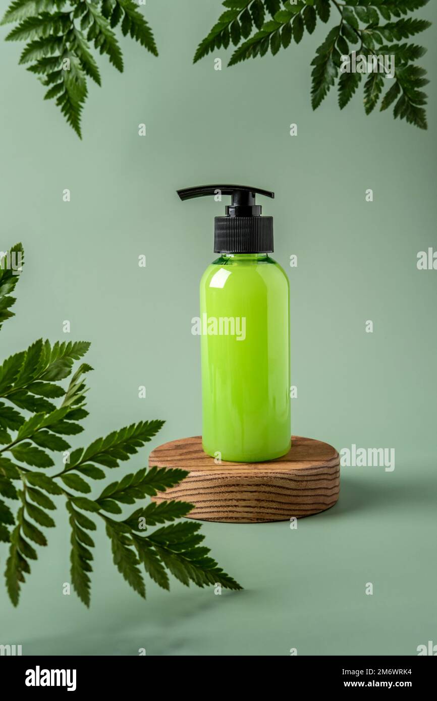 Bottiglia con dispenser su podio e fondo pastello. Contenitore cosmetico mockup con spazio per il testo. Bellezza naturale per la pelle pr Foto Stock