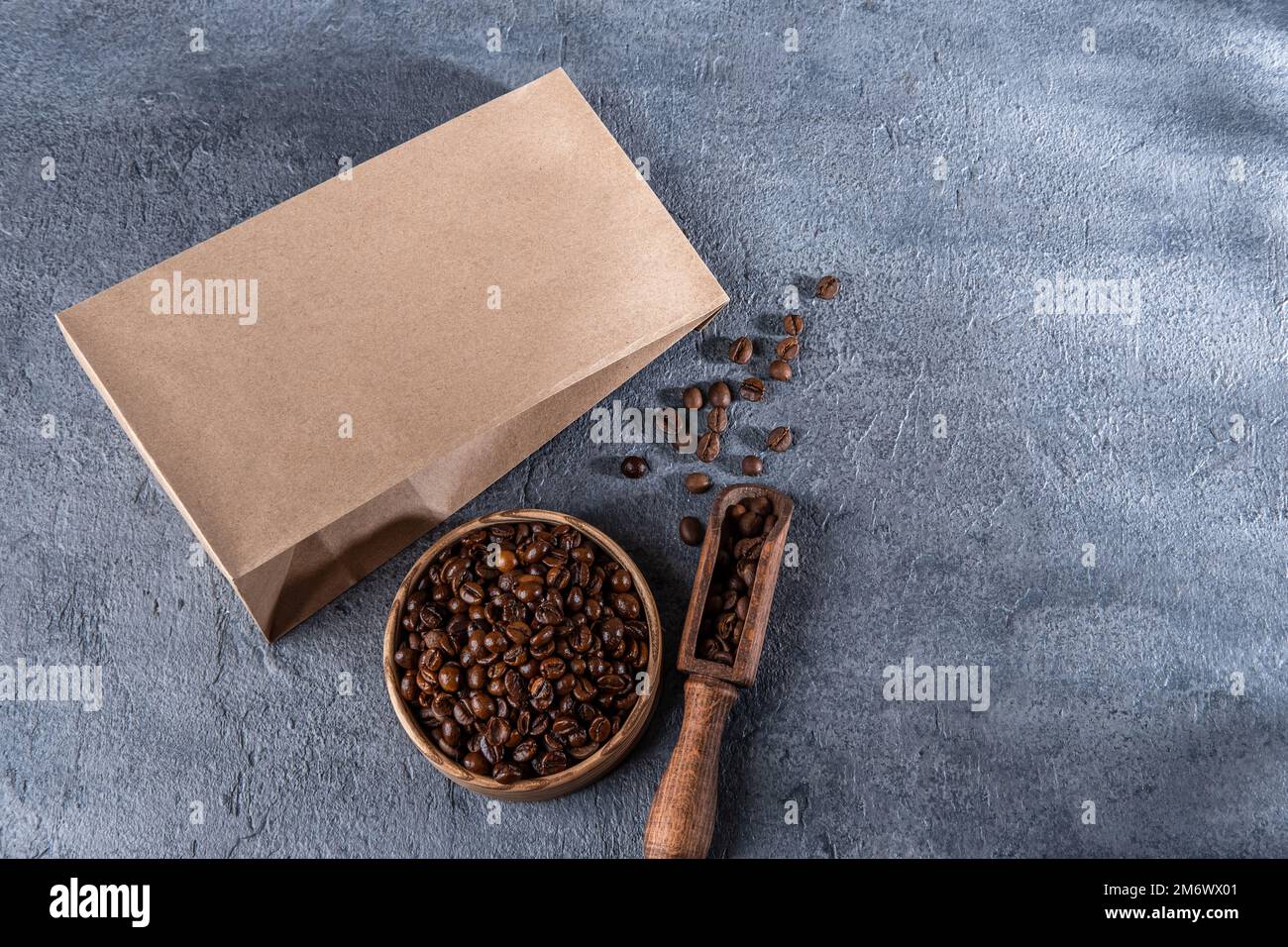 Mockup di branding per l'identità del caffè. Borsa artigianale marrone vuota con chicchi di caffè. Modello di confezione per logo, marchio, adesivo, etichette Foto Stock