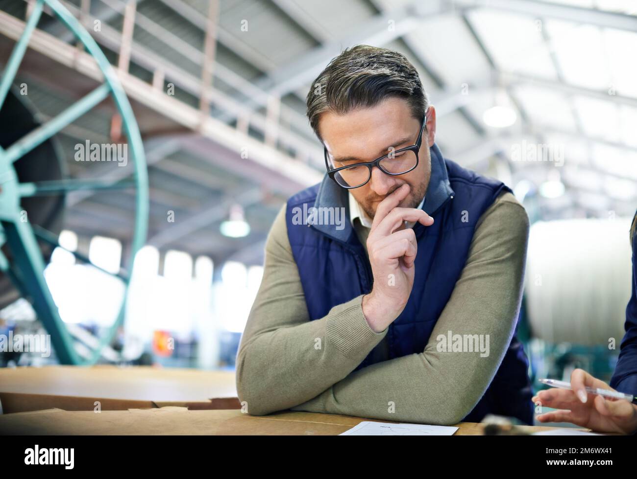 Pesare con cura ogni opzione. un uomo che lavora in un grande magazzino. Foto Stock