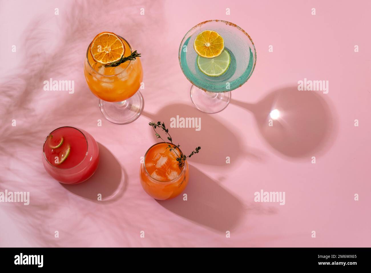 Cocktail tropicali colorati. Rinfrescanti bevande estive colorate su sfondo rosa con foglie di palma ombra. Menu di bevande del bar. Foto Stock