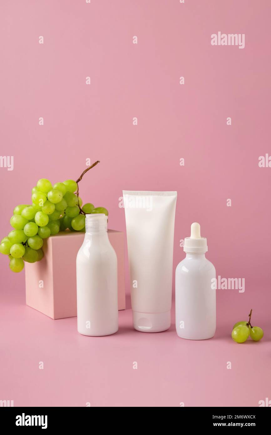 Bottiglia mock up per il branding con olio di semi d'uva sul podio. Set di confezionamento cosmetici. Prodotto cosmetico per la cura della pelle. Foto Stock